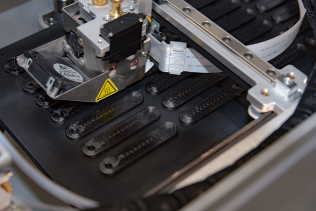 Markforged 3D printer printing an Onyx sample piece in carbon fiber